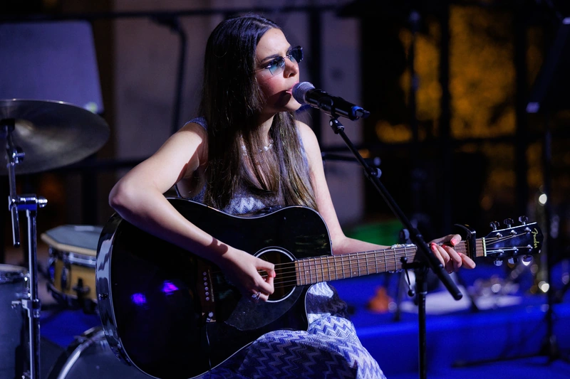 Sirine singing and playing acoustic guitar at the Parieté Gala in Berlin.
